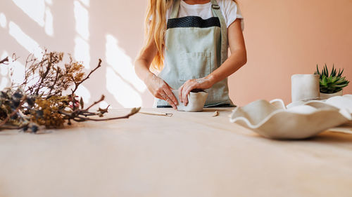 Midsection of woman standing on table