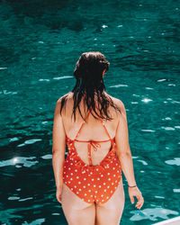 Rear view of woman standing in swimming pool