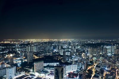 High angle view of illuminated buildings against sky at night