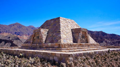 Built structure on mountain against blue sky