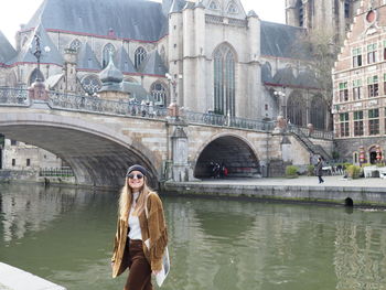 Woman on bridge over river in city