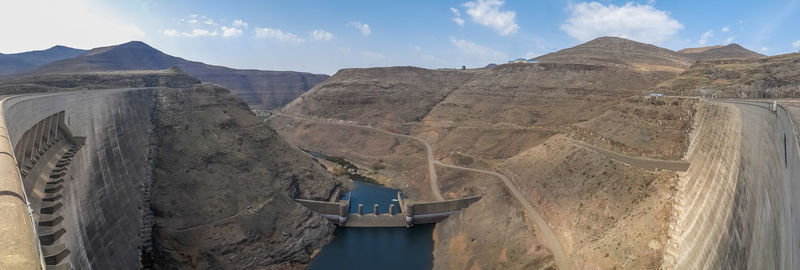 Panoramic view of dam and mountains against sky