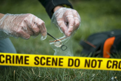 Cropped hands collecting evidence at crime scene