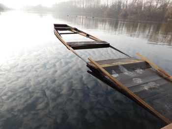 Reflection of boat in lake against sky