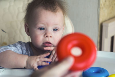 Portrait of cute baby girl holding table