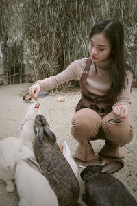 Side view of young woman sitting on field