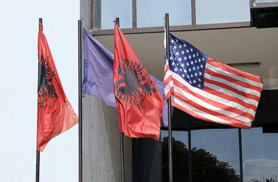 The flags of kosovo, albania, and the united states waving in the wind