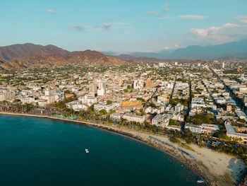 High angle view of townscape by sea against sky