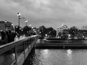 Bridge over river against buildings in city