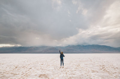 Full length of woman standing on white flats against sky