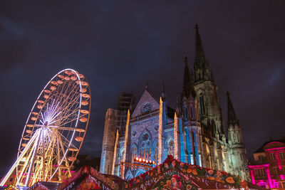 Low angle view of illuminated ferris wheel against sky at night