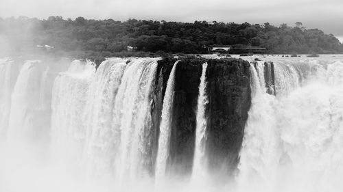 Scenic view of waterfall against sky