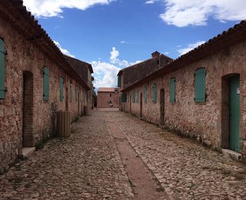 Street amidst houses against sky