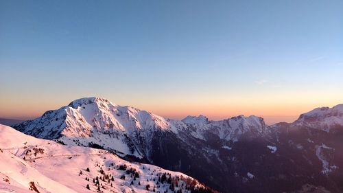Scenic view of snowcapped mountains against clear sky during winter
