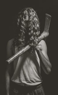 Rear view of man standing against black background