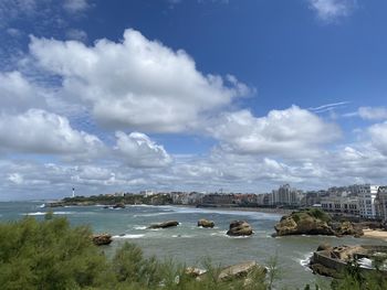 Scenic view of river by city against sky