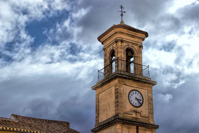 Low angle view of clock tower against cloudy sky