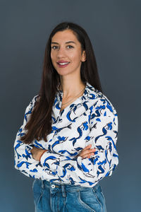 Portrait of a smiling young woman against black background