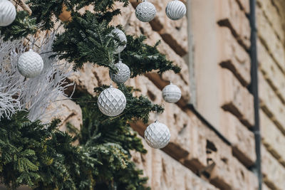 Christmas ourdoor decoration on the building. pine branches and classical christmas balls 
