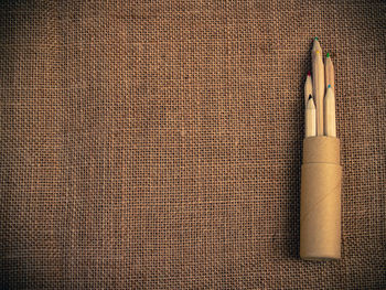 Directly above shot of pencils in container on burlap