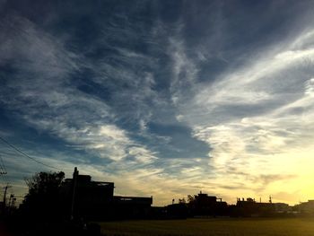 Silhouette of building against cloudy sky