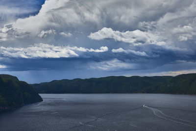 Scenic view of road by mountains against sky