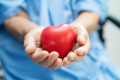 Midsection of woman holding heart shape