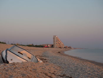 Scenic view of beach against clear sky during sunset