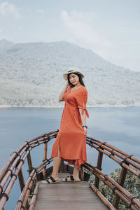 Woman standing on railing against sea