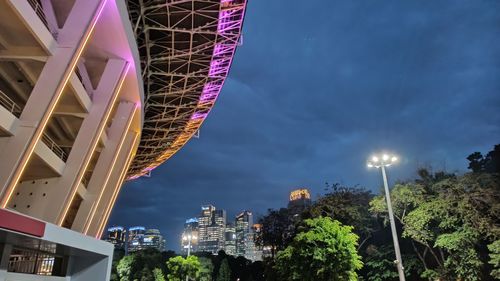 Low angle view of illuminated ferris wheel in city against sky