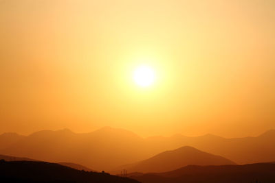 Scenic view of silhouette mountains against romantic sky at sunset