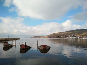 Boats moored on sea against sky