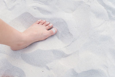 Low section of woman on sand