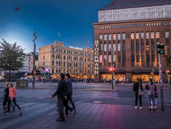 People walking on street in city at dusk