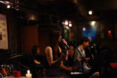 Young woman playing piano at music concert