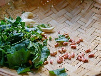 Long bean seeds, ivy gourd leaves, and cork wood tree flowers being prepared for cooking 