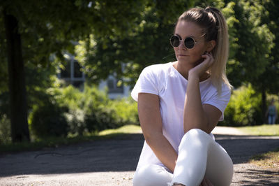 Portrait of beautiful woman in sunglasses against trees