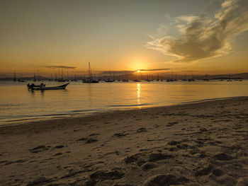 View of boats in sea at sunset