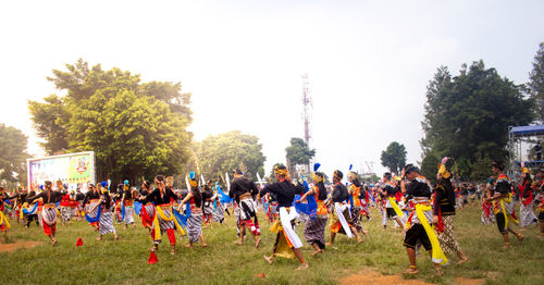 Group of people on field against trees