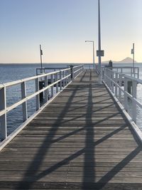 Pier over sea against sky during sunset