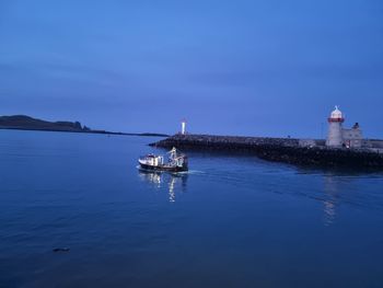 Lighthouse by sea against sky