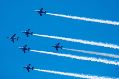 Low angle view of airplane flying against blue sky