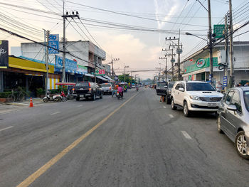 Cars on road against sky in city