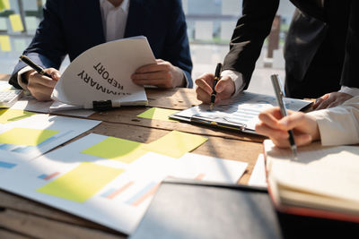 Midsection of business colleagues working on table