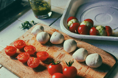 Close-up of tomato with cheese on cutting board