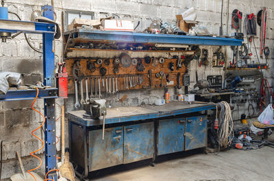 Old collection of various repair tools hangs on wall above table. workshop with tools. side view