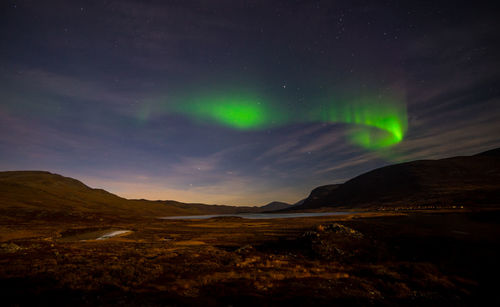 Scenic view of landscape against star field at night