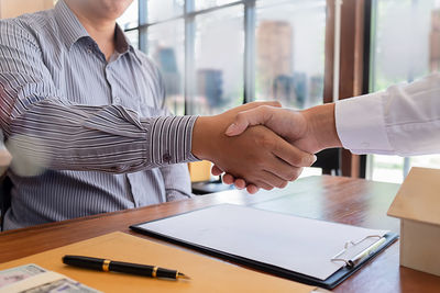 Business people handshaking at desk in office