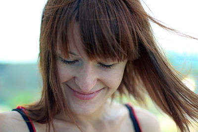 Close-up of smiling woman with eyes closed at beach