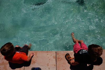 High angle view of boys sitting by pool